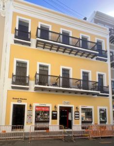 un edificio amarillo con balcones encima en 310Guest-House La Vyda, en San Juan