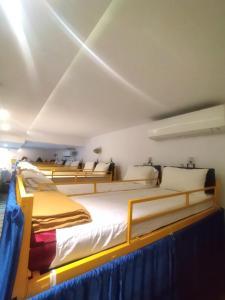 a bedroom with four beds in a room at New Mango Dormitory in Mumbai