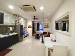 cocina y sala de estar con sofá y mesa en Taragon Time Service Suite en Kuala Lumpur
