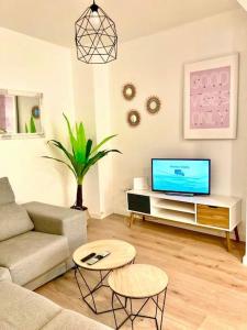 a living room with a couch and a tv at Málaga center city in Málaga