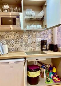 a kitchen with a sink and a microwave at Málaga center city in Málaga