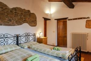 1 dormitorio con 2 camas y pared de piedra en Reggioli- Appartamento Erborista, en Gaiole in Chianti