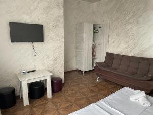 uma sala de estar com um sofá e uma televisão em Emilia em Batumi