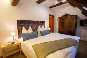 sypialnia z dużym łóżkiem z drewnianym zagłówkiem w obiekcie Ökonomiehof w mieście Lichtenfels