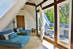 salon z niebieską kanapą i oknami w obiekcie Ökonomiehof w mieście Lichtenfels