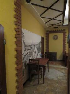 a dining room with a table and a painting on the wall at Hostel Jan in the very center in Yerevan