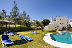 un cortile con sedie, una piscina e un edificio di Gorgeous renovated Apt near golf and sea RDR373 a Marbella