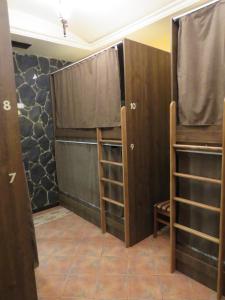 Habitación con puertas y estanterías de madera en Hostel Jan in the very center, en Ereván