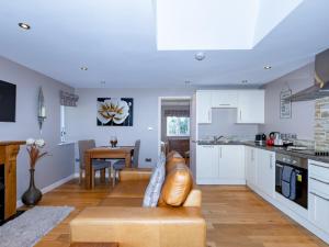 eine Küche und ein Wohnzimmer mit einem Sofa und einem Tisch in der Unterkunft Pass the Keys Stylish Garden cottage in Wells, Somerset in Wells