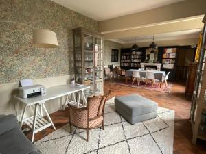sala de estar con escritorio, mesa y sillas en Suite près de Chambord, en Saint Laurent Nouan