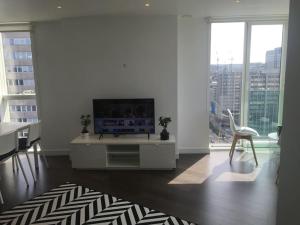 a living room with a flat screen tv on a white wall at GRAND SERVICED APARTMENT***** in Croydon