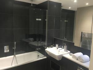 a bathroom with a sink and a shower and a tub at GRAND SERVICED APARTMENT***** in Croydon