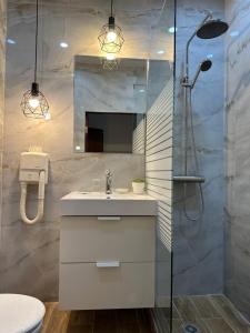 a bathroom with a sink and a shower at Hotel Art in Varna City