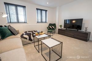 a living room with a couch and a flat screen tv at Elegant townhouse, Westbourne, Sleeps 8, Parking - The Hideaway in Bournemouth