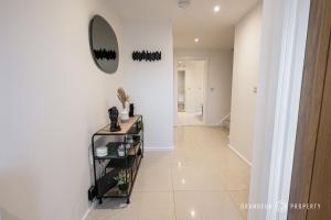 a hallway with a mirror on a white wall at Elegant townhouse, Westbourne, Sleeps 8, Parking - The Hideaway in Bournemouth