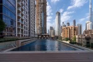 een groot zwembad in een stad met hoge gebouwen bij Burj Khalifa View 2BR Spacious Bellevue Tower in Dubai