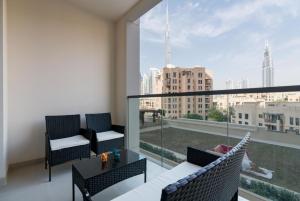 een balkon met 2 stoelen, een tafel en een groot raam bij Burj Khalifa View 2BR Spacious Bellevue Tower in Dubai