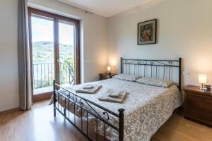 ein Schlafzimmer mit einem Bett und einem großen Fenster in der Unterkunft Casa Elsa - Lago d'Orta in Orta San Giulio