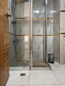 La salle de bains est pourvue d'une douche avec une porte en verre. dans l'établissement Serenity suites Hotel, à Antalya