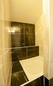 塔昌什卡什特爾巴的住宿－Enchanted Forest Chalet，浴室设有黑色瓷砖和淋浴。