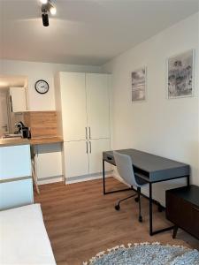 um quarto com uma secretária, uma mesa e uma cozinha em helloYOU Apartments em Ingelheim am Rhein