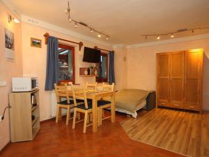 comedor con mesa, sillas y microondas en Apartma Felix, en Kranjska Gora