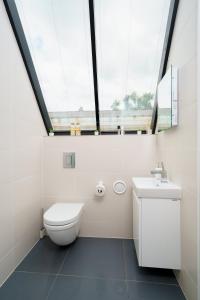 a bathroom with a toilet and a sink and a window at En-suite Room in Zone 1 London in London