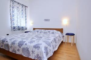 1 dormitorio con 1 cama con edredón azul y blanco en Apartment Bujas, en Šilo