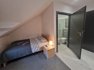 ein kleines Schlafzimmer mit einem Bett und einem Badezimmer in der Unterkunft Willa Lawenda in Rytro