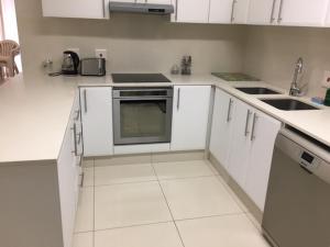 a white kitchen with white cabinets and appliances at Ballito Sands in Ballito