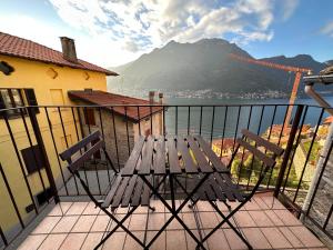 a picnic table on a balcony with a view of a mountain at La Casa del Mastro - Como Lake in Pognana Lario