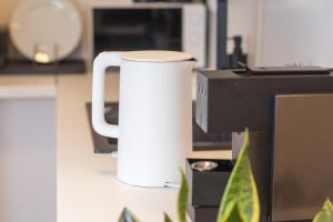 - une tasse de café blanc assise à côté d'un four micro-ondes dans l'établissement Hamburg Apartment für bis zu 4 Personen, à Hambourg