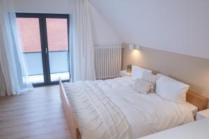 Cette chambre comprend un lit blanc et une grande fenêtre. dans l'établissement Hamburg Apartment für bis zu 4 Personen, à Hambourg