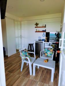 ein Wohnzimmer mit 2 Stühlen und einem Tisch in der Unterkunft Sea Breeze inn 102 in Providencia