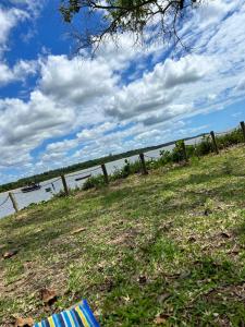 a fence on the side of a field next to the water at Pousada na fazenda! Venha descansar! in Serra