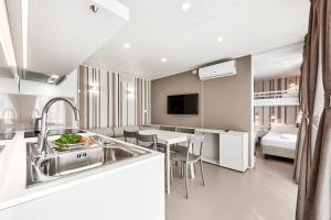 a kitchen and living room with a sink and a table at Etruria Camping Village in Marina di Castagneto Carducci