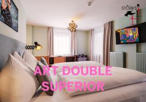a bedroom with a large bed with a pink sign at Hotel Bad Hofgastein - The STORKS - Adults Only - Bergbahnen bis November inklusive in Bad Hofgastein