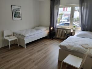 a bedroom with two beds and a window at DWK: Monteurhaus Bad Salzig in Boppard