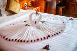 two swans in a dress on a bed at Noi Bai The King Hotel in Sóc Sơn