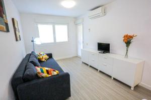sala de estar con sofá y TV en Grekus Litoral - ONLY FAMILIES, en Cambrils