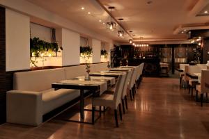 une salle à manger avec des tables et des chaises blanches dans l'établissement Malinowy Dwór Hotel Medical SPA, à Świeradów-Zdrój