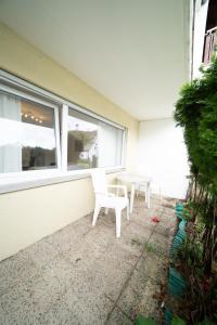 博帕德的住宿－DWK: Monteurhaus Bad Salzig，两把白色的椅子和一张桌子,位于窗户前