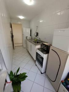 una pequeña cocina con fogones y nevera. en Apartamento Barra Villa d Italia HIR 32, en Río de Janeiro