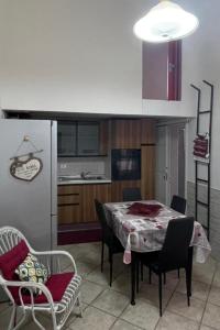 eine Küche mit einem Tisch und Stühlen sowie einem Kühlschrank in der Unterkunft Casa Graziella in Brindisi