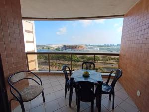 a table and chairs on a balcony with a view at Apartamento Barra Villa d Italia HIR 32 in Rio de Janeiro