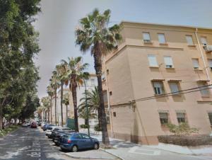 a building with palm trees on the side of a street at New Apartment & Parking Alcazaba in Málaga