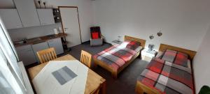 Oettingen in BayernにあるFerienwohnung Stempfleのベッド2台、テーブル、キッチンが備わる客室です。
