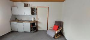 a small kitchen with a chair with a red pillow at Ferienwohnung Stempfle in Oettingen in Bayern