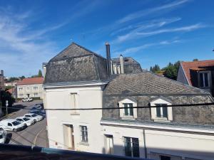 an old white building with a gray roof at bel appartement,confortable,2chambres in Briey