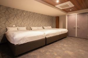 Un pat sau paturi într-o cameră la ピンポンホテル&キャビン pin pon hotel & cabin